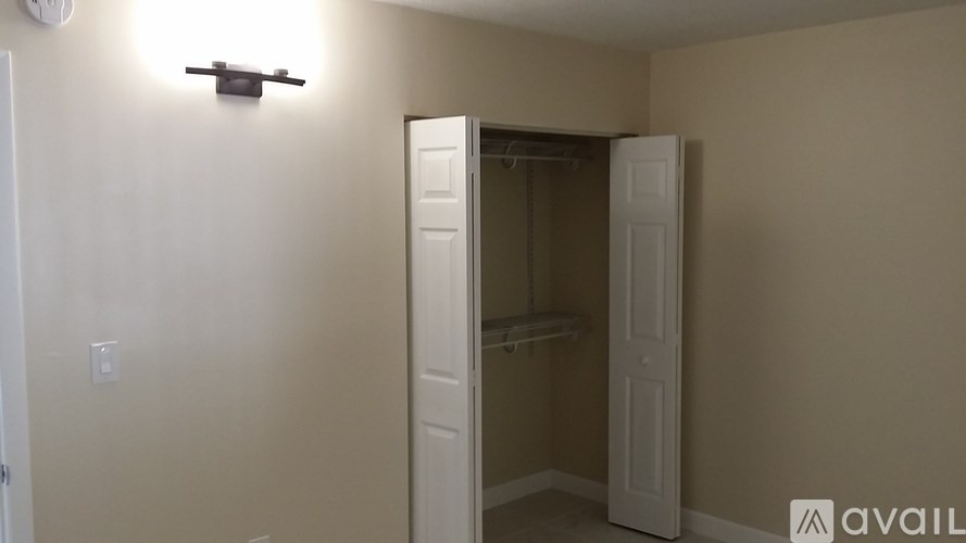 A room with a white door and a light switch on the wall.