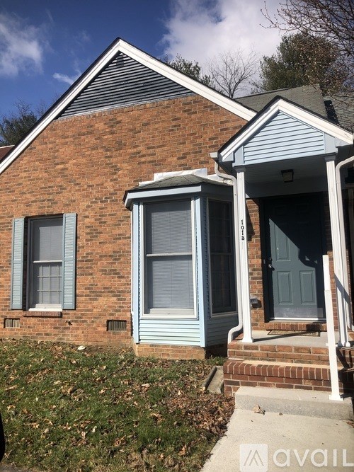 A house with a brick facade and a blue door.
