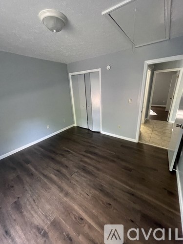 A room with wooden flooring and two doors.