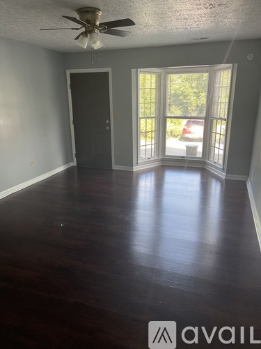 A room with a ceiling fan and sliding glass doors.
