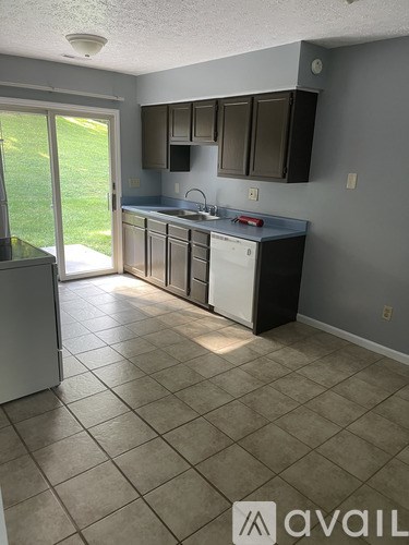 A kitchen with tile flooring and a dishwasher.