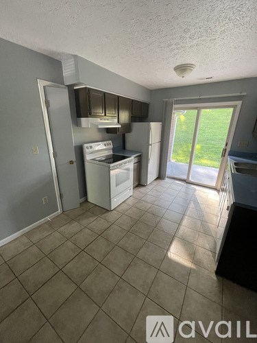 A kitchen with tile flooring and a stove top oven.