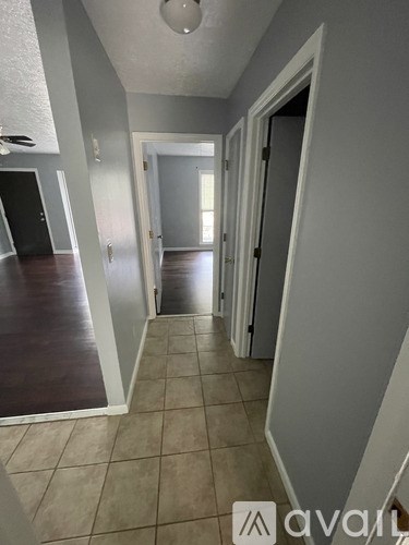 A hallway with tiled floors and white walls.