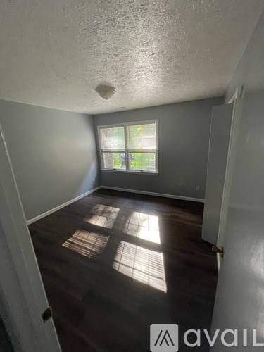 A room with a window and wooden floors.