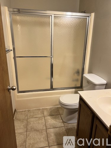 A bathroom with a toilet, sink, and shower.