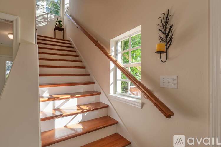 A staircase with wooden steps and a light brown handrail.