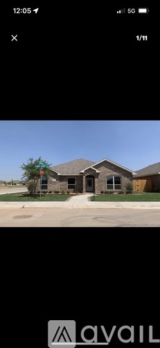 A house with a driveway and a tree in front of it.
