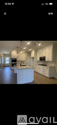 A modern kitchen with white cabinets and a central island.