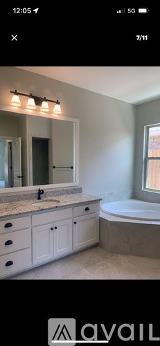 A bathroom with a tub, sink, and mirror.