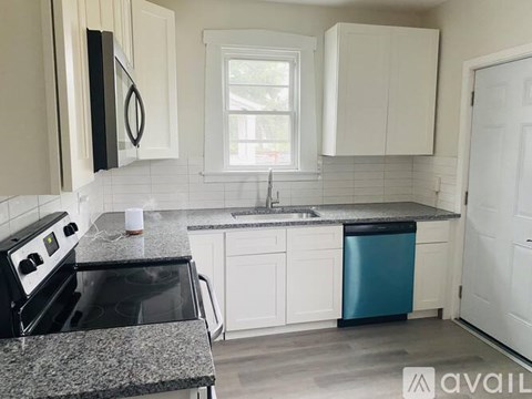 A kitchen with a black stove top oven and a black dishwasher.