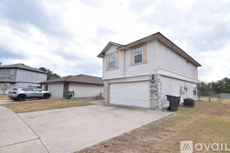 A house with a garage and a car parked in front.