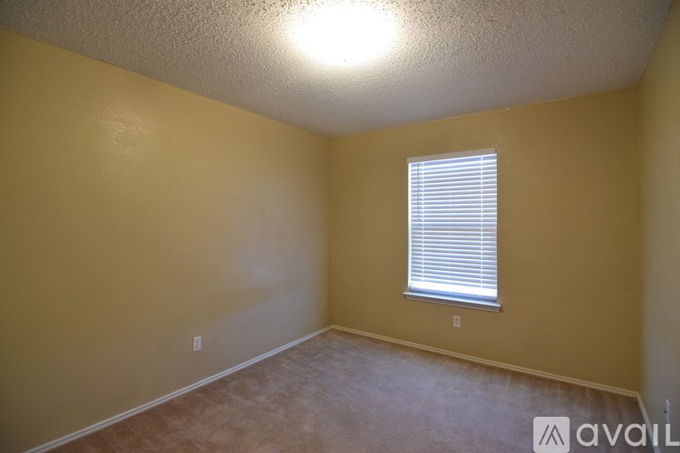 A room with a window and a carpeted floor.