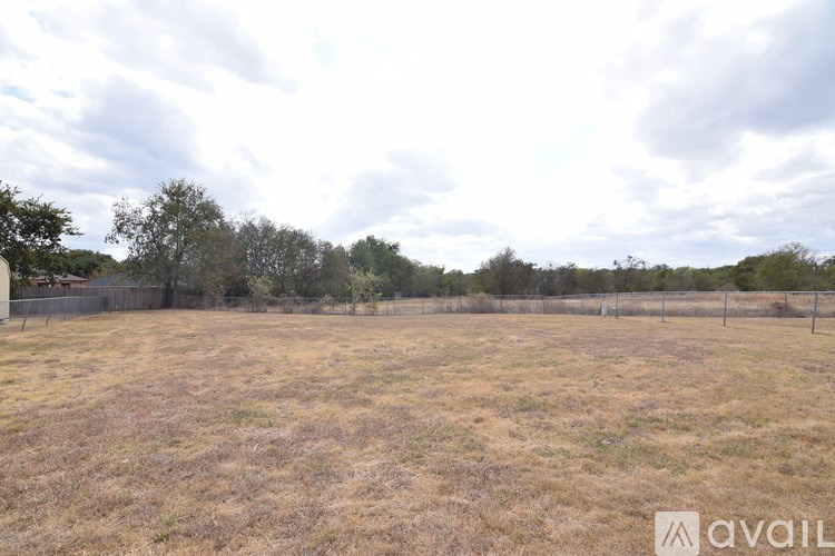 A field with dry grass and a cloudy sky.