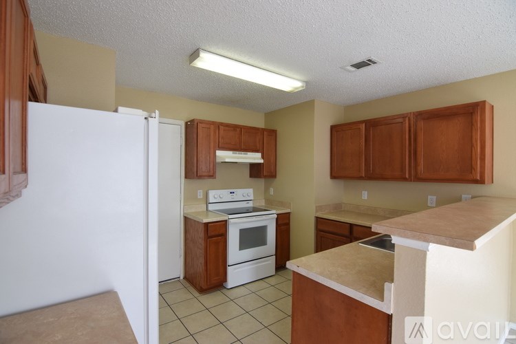 A kitchen with white appliances and brown cabinets.