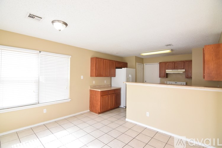 A kitchen with white appliances and wooden cabinets.