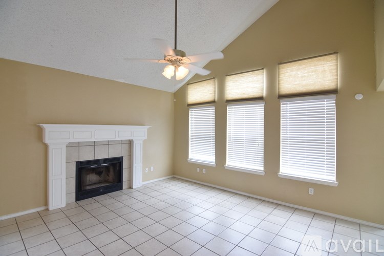 A living room with a fireplace and a fan.