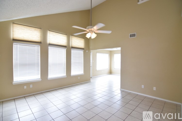 A room with a ceiling fan and tiled flooring.