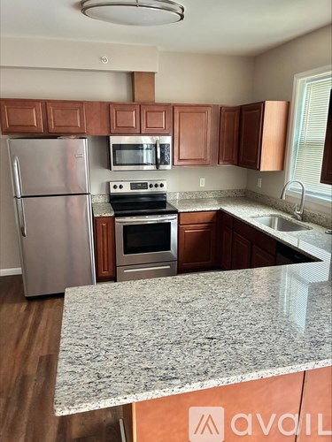 A kitchen with a granite countertop and stainless steel appliances.