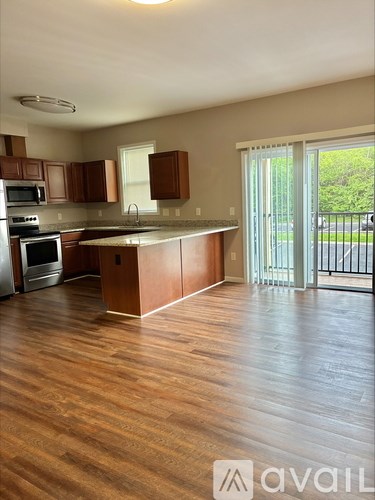 A kitchen with wooden cabinets and a wooden floor.