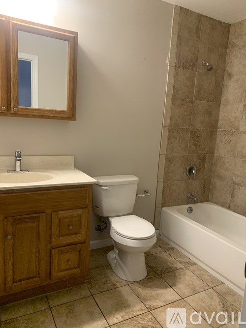 A bathroom with a toilet, sink, and bathtub.