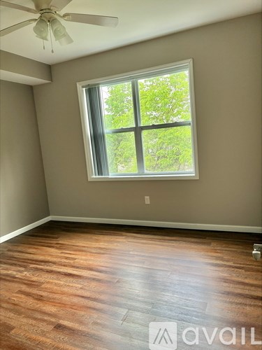A room with a window and a ceiling fan.