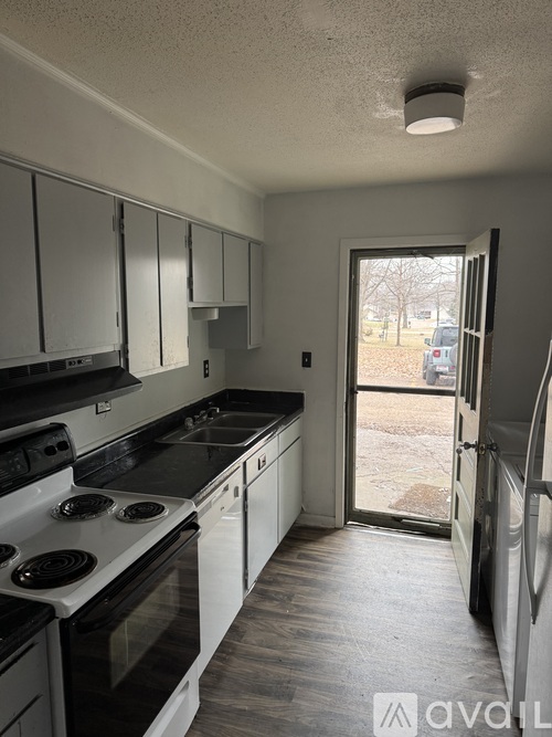 A kitchen with white cabinets and black appliances.