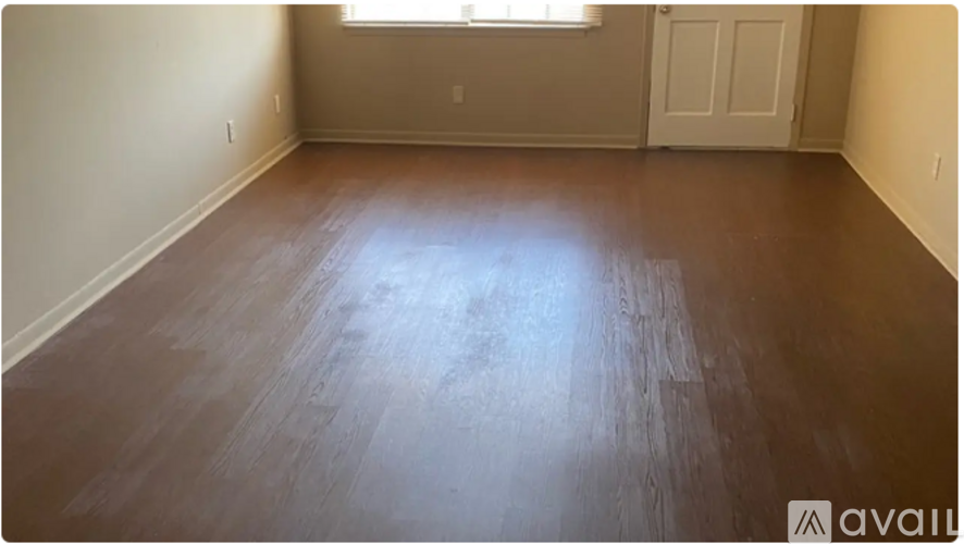A room with wooden flooring and a window.