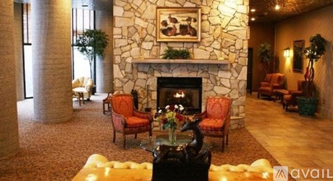 A living room with a stone fireplace and a painting above it.