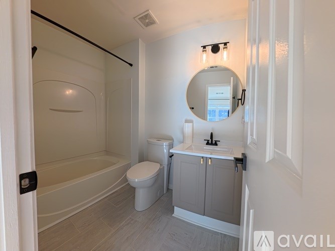 A bathroom with a toilet, sink, and bathtub.