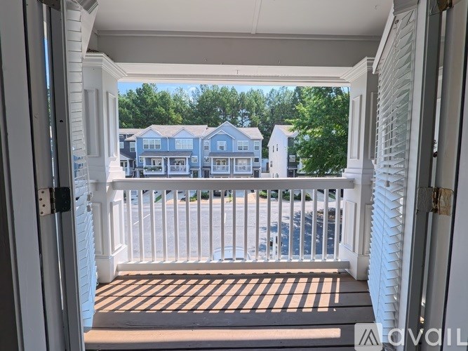 A balcony view of a residential area with houses and trees.