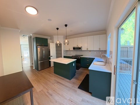 A kitchen with green cabinets and a white countertop.