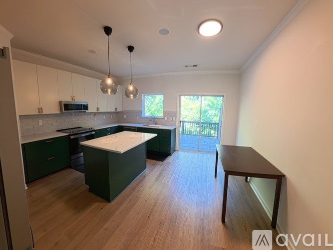 A kitchen with green cabinets and a wooden floor.