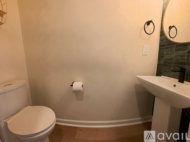 A bathroom with a toilet, sink, and mirror.