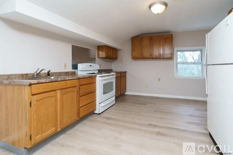 A kitchen with wooden cabinets and a white fridge.