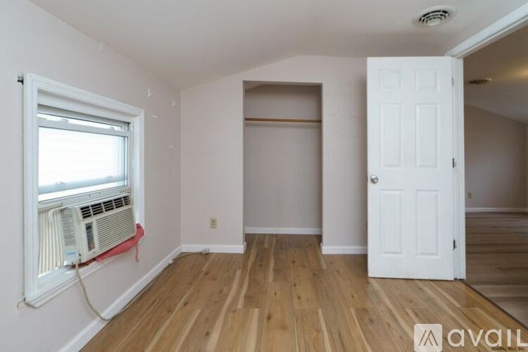 A room with a window and a door is available for rent.