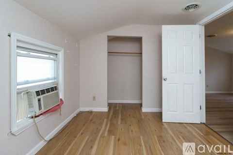 A room with a window and a door is available for rent.