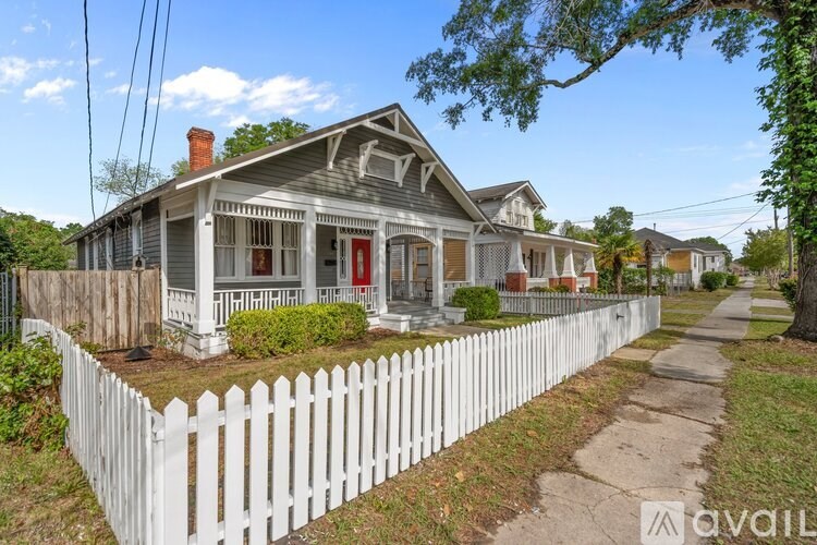 A white picket fence surrounds a charming house.
