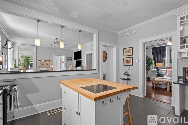 A kitchen with a wooden island and white cabinets.