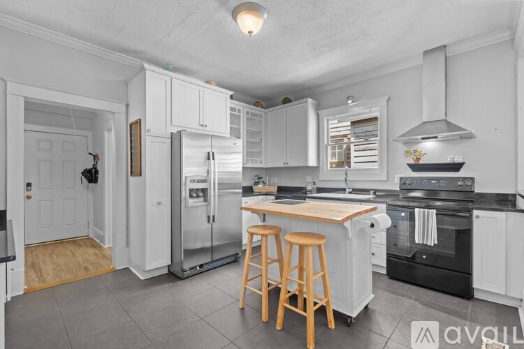 A kitchen with white cabinets and a black stove top oven.