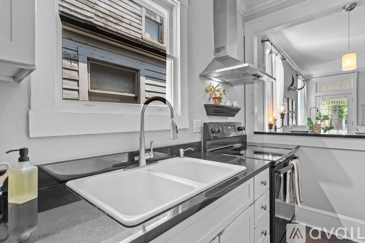A modern kitchen with a stainless steel sink and a window above the oven.