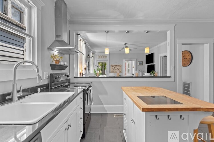 A modern kitchen with a wooden island and stainless steel appliances.