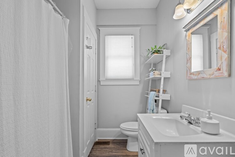 A bathroom with a white sink and a white toilet.