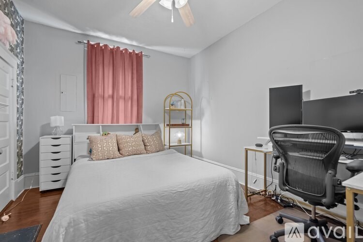 A bedroom with a bed, desk, and chair.