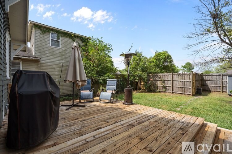 A wooden deck with a grill and chairs.