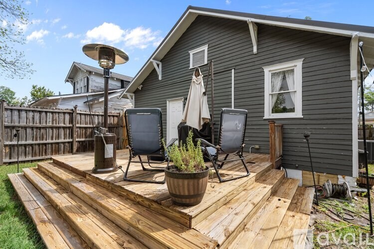 A wooden deck with two chairs and a table.
