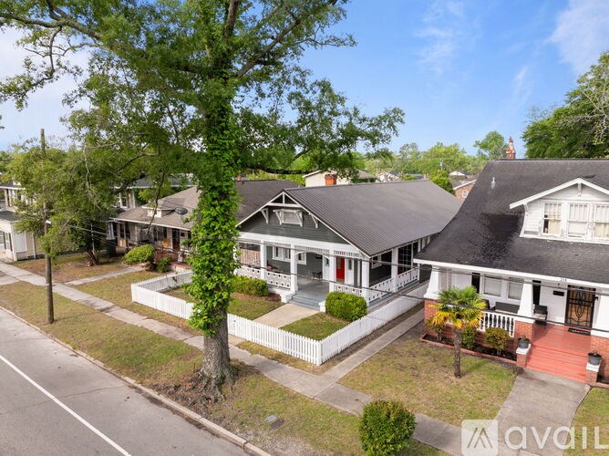 A row of houses with a tree in front of the first one.