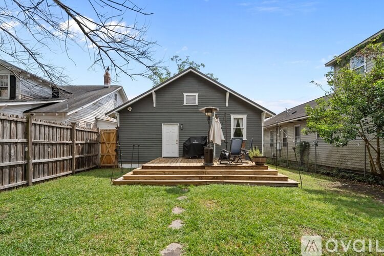 A grey house with a white door and a small porch.
