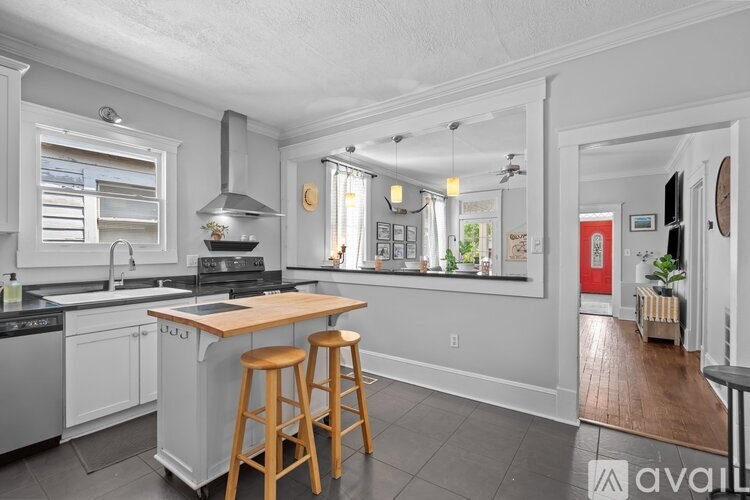 A kitchen with white cabinets and a wooden island.