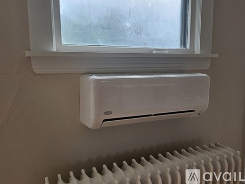 A wall-mounted air conditioner is installed next to a window.