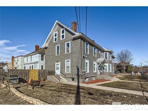 A grey house with a brown fence in front of it.